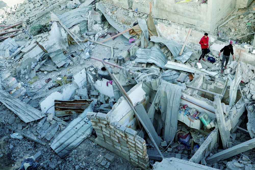 Palestinians inspect the site of an Israeli strike on a house, in Khan Yunis in the southern Gaza Strip. — Reuters