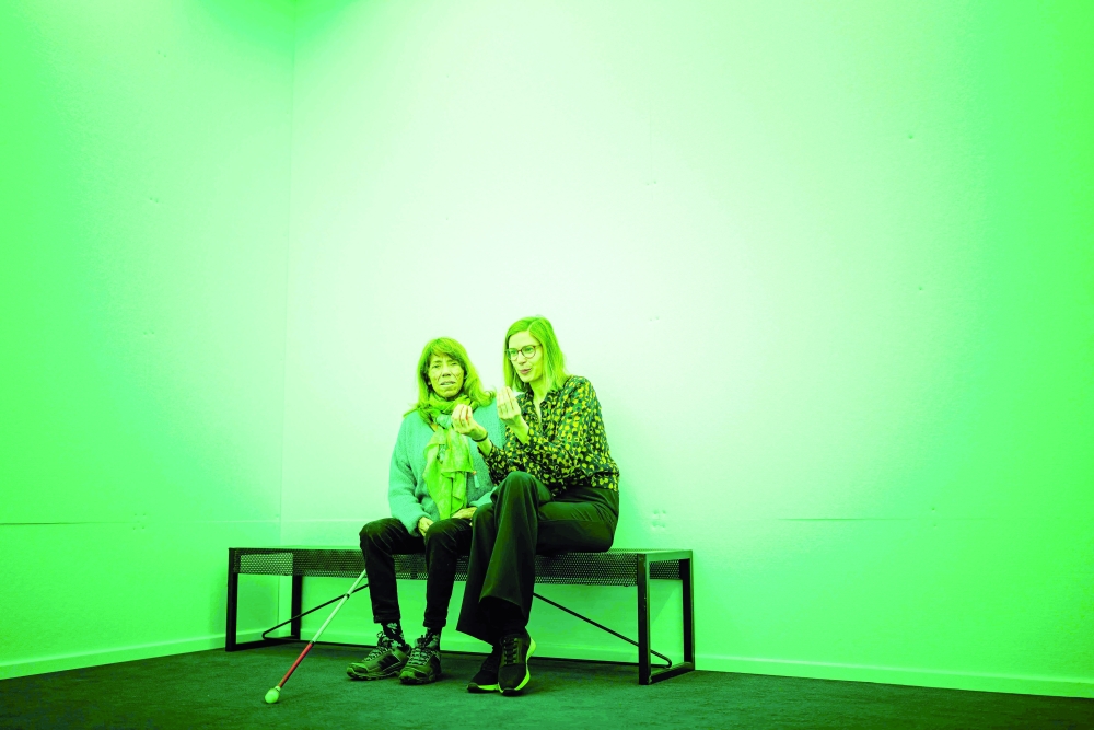 Karin (L) and her image whisperer Alice Baronnet sit in a green room as they take part in a guided tour for visually impaired people at the International Red Cross and Red Crescent Museum in Geneva. - AFP