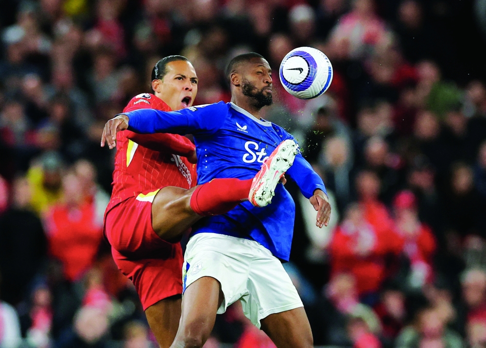 Liverpool's Virgil van Dijk in action with Everton's Beto. — Reuters