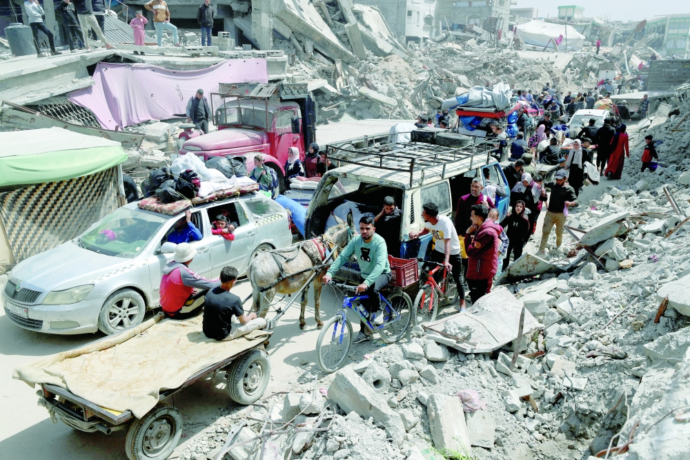 Palestinians make their way with belongings as they flee their homes, in the Shujaiya neighbourhood of Gaza City. — Reuters