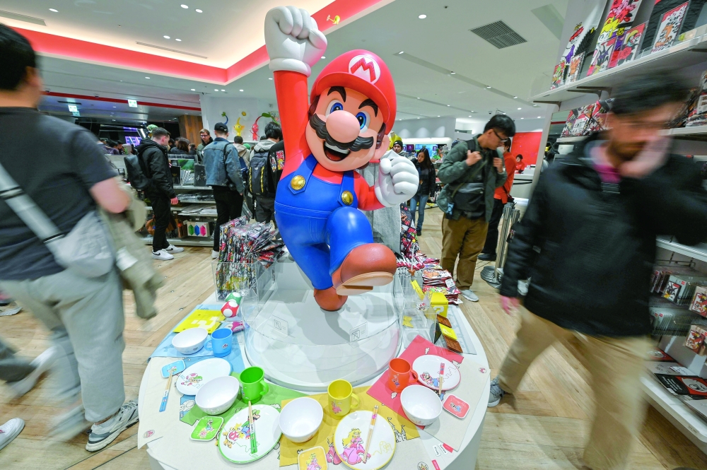 Customers walk past a display for Super Mario in Tokyo's Shibuya district. — AFP