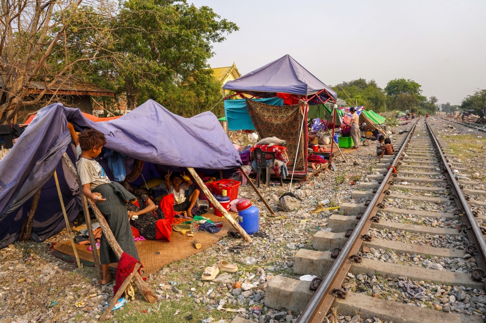 People are seen at a shelter in a makeshift tent camp near a railway track, in Amarapura township, Myanmar. — Reuters