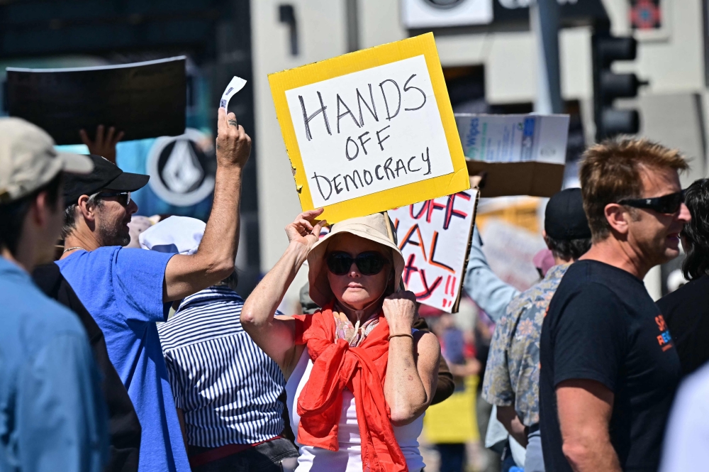 A protester holds a sign during a "Hands Off!" protest against the policies of US President Donald Trump