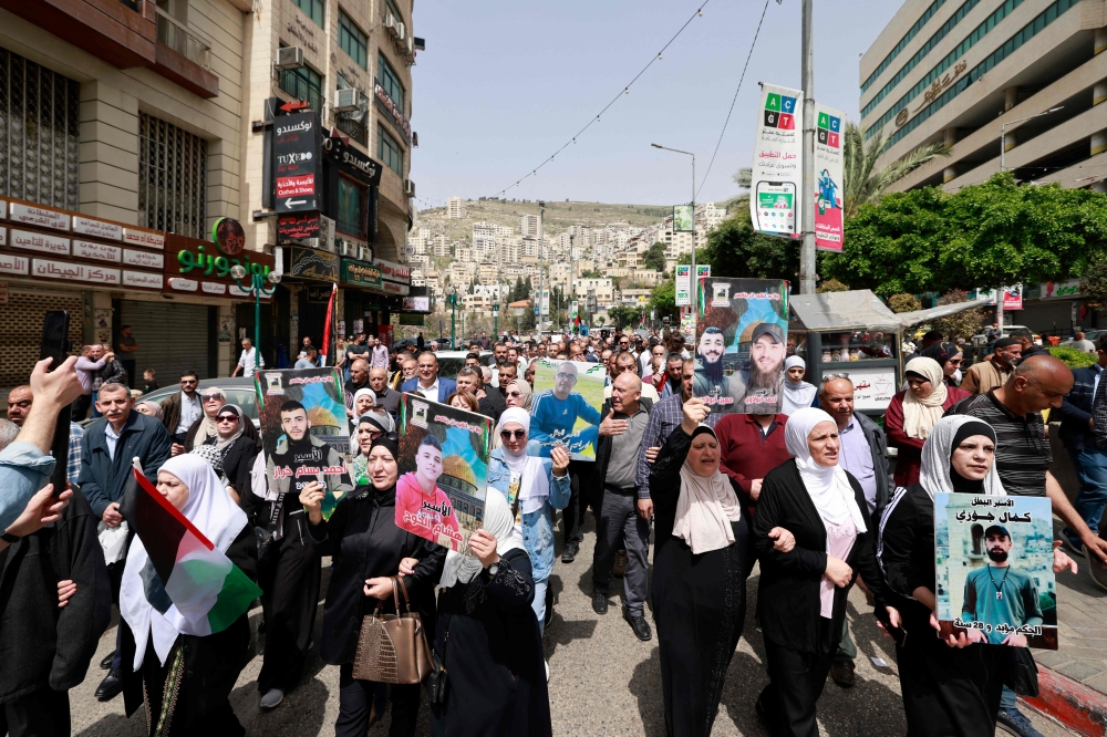 Palestinians chants slogans as they march, during a general strike demanding an end to the Gaza war, in Nablus. — AFP