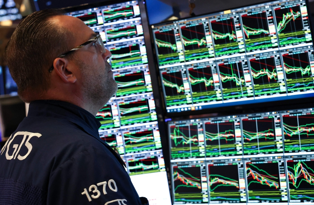 TOPSHOT - A trader works on the floor of the New York Stock Exchange (NYSE) at the opening bell in New York City, on April 7, 2025. Wall Street stocks opened sharply lower Monday, joining a global selloff on worries that a trade war induced by US President Donald Trump's tariffs will spark a global economic slowdown. (Photo by TIMOTHY A. CLARY / AFP)
