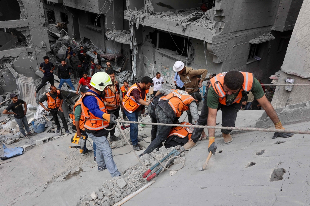 Palestinian rescuers work at the site of an Israeli strike on a residential area in Gaza City's Shujaiyya neighbourhood. — AFP