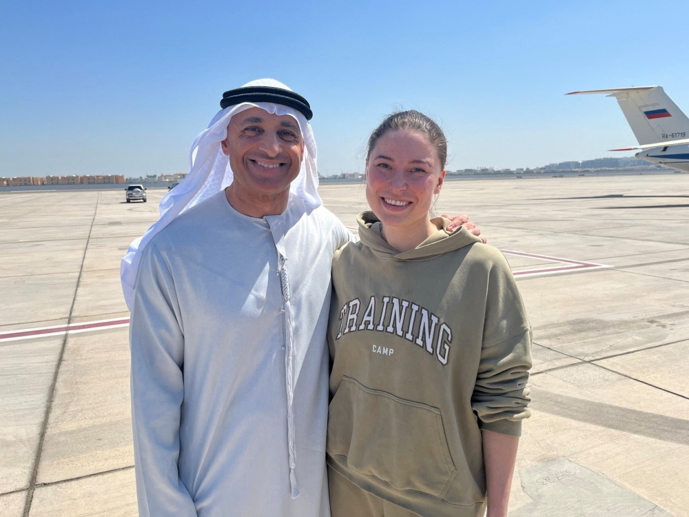 Yousef Al Otaiba, UAE Ambassador to the U.S., poses for a picture with Russian-American dual citizen Ksenia Karelina after being exchanged in a prisoner swap, at Al Bateen airport in Abu Dhabi, United Arab Emirates April 10, 2025.  UAE Ministry of Foreign Affairs/Handout via REUTERS    THIS IMAGE HAS BEEN SUPPLIED BY A THIRD PARTY