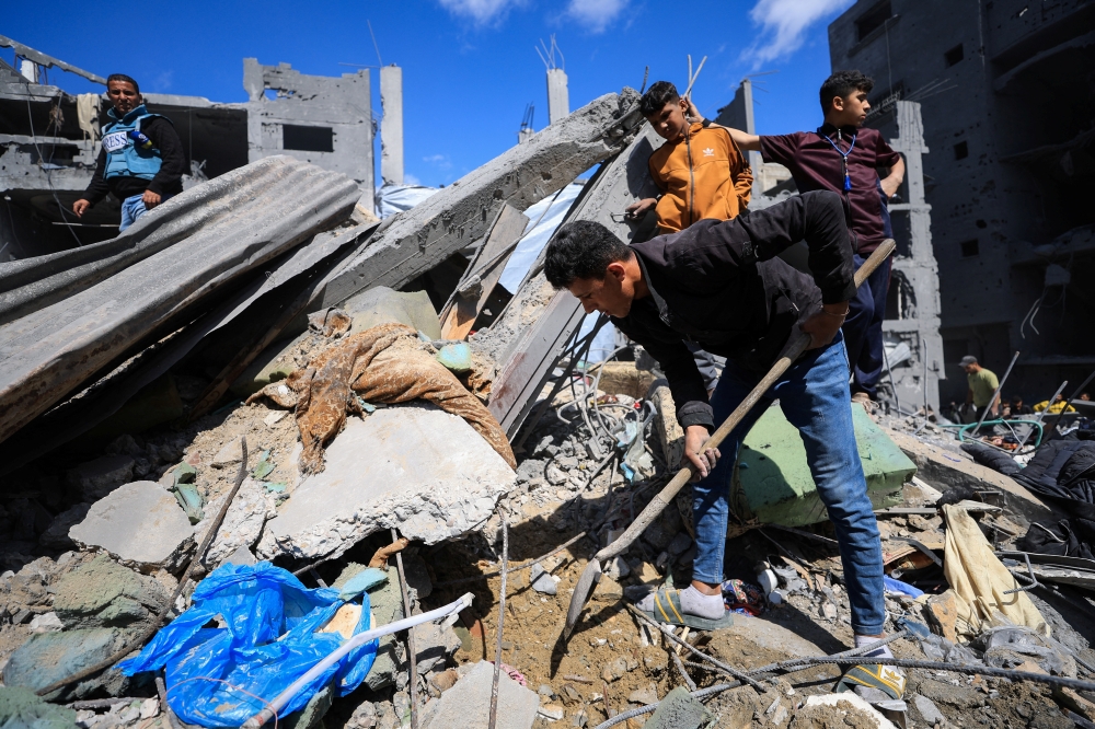 Palestinians search for casualties trapped under the rubble, at the site of an Israeli airstrike that hit a house the previous day in Shejaia, Gaza City. - Reuters 
