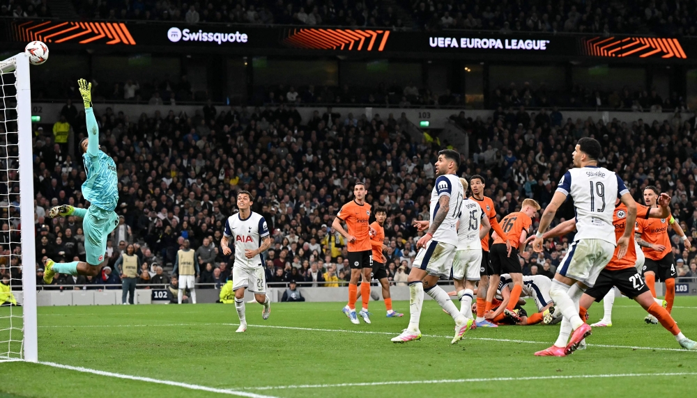 Eintracht Frankfurt's Brazilian goalkeeper #40 Kaua Santos dives to cover a side shot during the UEFA Europa League quarter-final football match between Tottenham Hotspur and Eintracht Frankfurt at the Tottenham Hotspur Stadium in London, on April 10, 2025.  (Photo by Glyn KIRK / AFP)