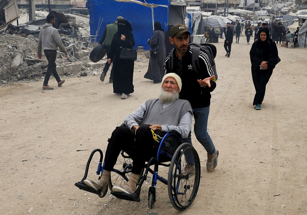 Palestinians make their way as they flee areas in the eastern part of Gaza City, after the Israeli army issued evacuation orders, in Gaza City, April 11, 2025. REUTERS/Dawoud Abu Alkas
