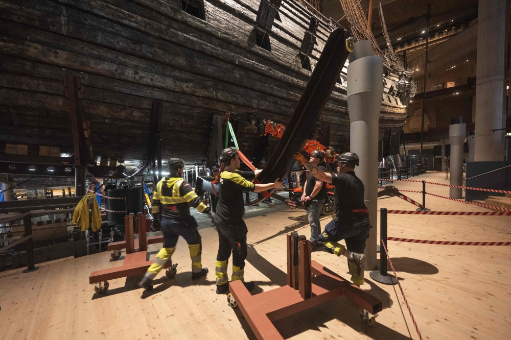 Workers install a new metallic support structure for the 17th-century warship Vasa at the Vasa Museum in Stockholm, Sweden, on April 8, 2025. The new structure will replace the current one, which has been damaging the ship over time. The royal warship Vasa sank in 1628 and was salvaged more than 300 years later. (Photo by Jonathan NACKSTRAND / AFP)

