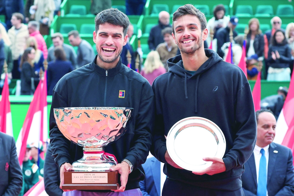 Spain's Carlos Alcaraz (L) celebrates with the trophy after winning the Monte Carlo Masters with runner-up Italy's Lorenzo Musetti. — AFP