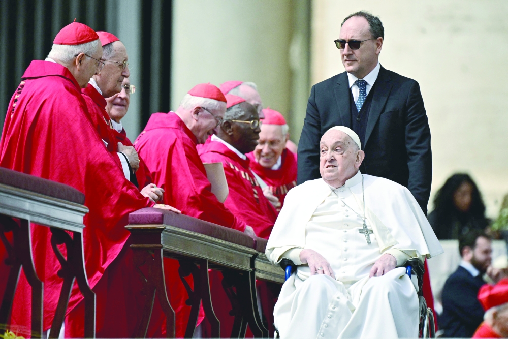Pope Francis greets cardinals at the end of the mass for Palm Sunday at St Peter's square in the Vatican. — AFP