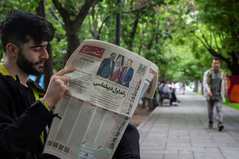A newspaper reader on a park bench in Tehran, Iran, April 12, 2025. (Arash Khamooshi/The New York Times)