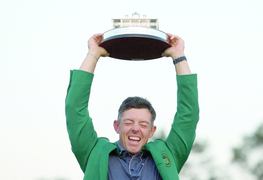 Northern Ireland's Rory McIlroy celebrates with his green jacket and the trophy after winning The Masters and completing a career grand slam REUTERS/Pilar Olivares     TPX IMAGES OF THE DAY