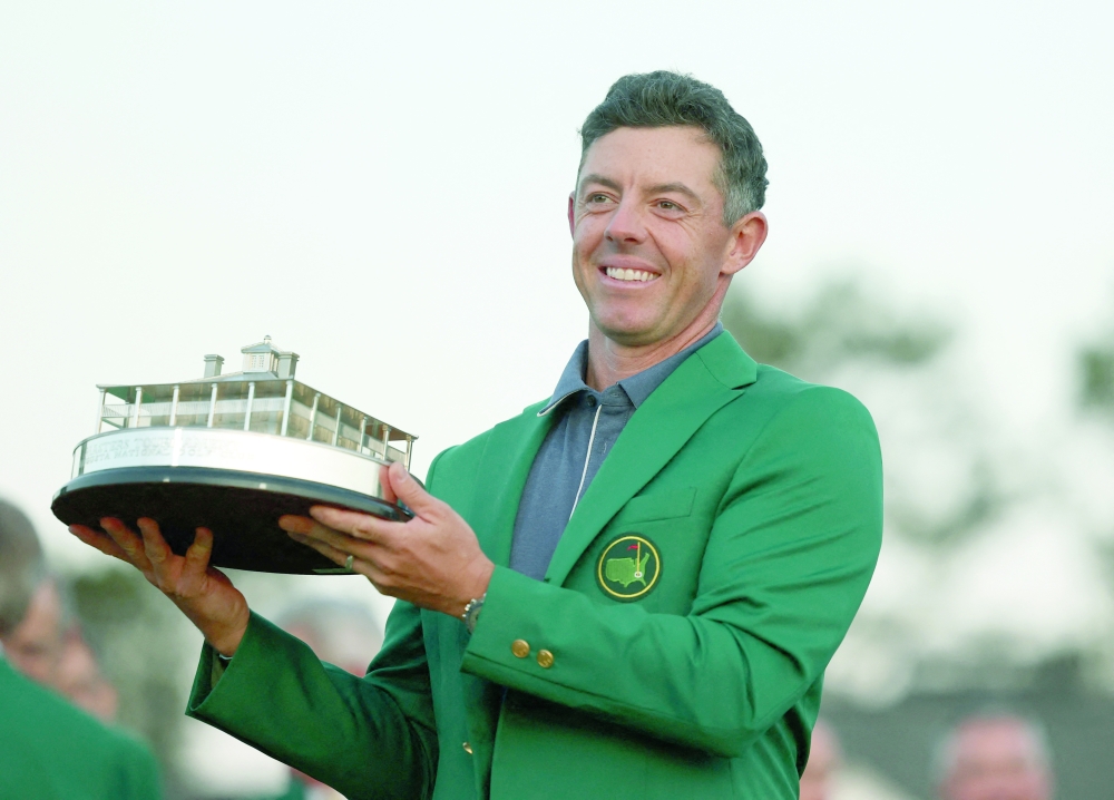 Northern Ireland's Rory McIlroy celebrates with his green jacket and the trophy after winning The Masters and completing a career grand slam REUTERS/Pilar Olivares