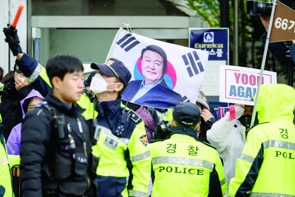 Police stand in front of pro-Yoon supporters outside the Central District Court, in Seoul. — AFP
