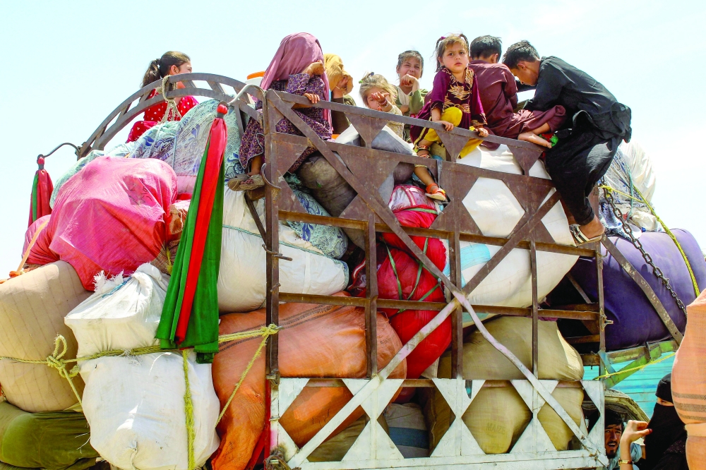 Afghan refugee children board a truck loaded with their belongings as they wait for their deportation to Afghanistan, at a holding centre near the Pakistan-Afghanistan border in Chaman on April 15, 2025. According to the UN refugee agency, more than 24,665 Afghans have left Pakistan since April 1, 10,741 of whom were deported. Convoys of Afghans pressured to leave Pakistan are driving to the border, fearing the "humiliation" of arrest, as the government's crackdown on migrants sees widespread public support. (Photo by Abdul BASIT / AFP)