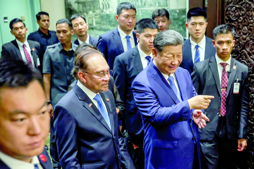 China's President Xi Jinping and Malaysia's Prime Minister Anwar Ibrahim look at the performance by the children before dinner at the official residence of the prime minister in Putrajaya. — AFP