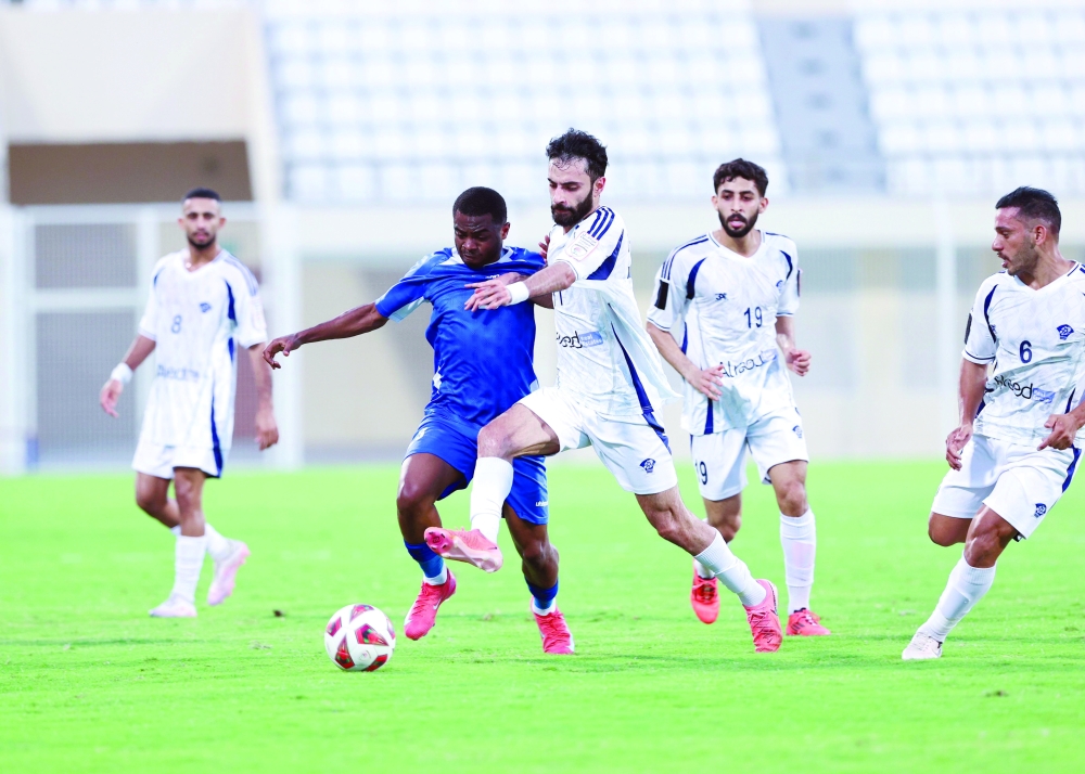 Al Shabab and Al Nasr players fight for the ball.