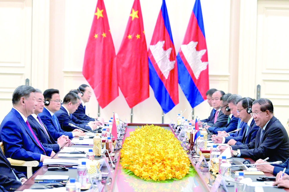 Cambodia's Senate President Hun Sen (R) speaks to China's President Xi Jinping (L) during a meeting at the Peace Palace, in Phnom Penh. — AFP