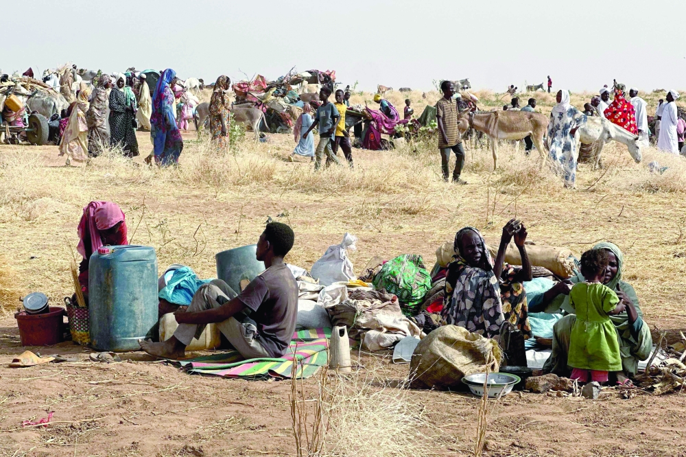 Displaced people rest in a makeshift encampment in an open field, Darfur region. — AFP