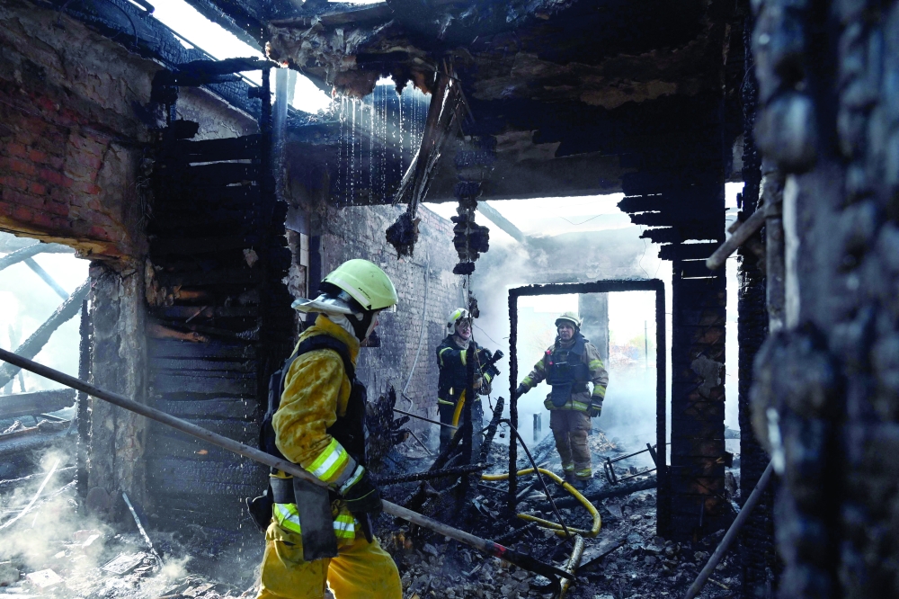 Ukrainian rescuers work to extinguish a fire in a sewing factory following a missile attack in Kharkiv. — AFP