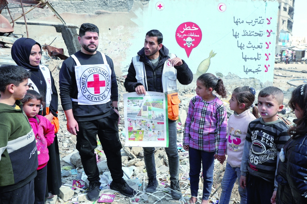 Red Cross members take part in a campaign to raise people's awareness about the danger of approaching ordnance, in Khan Yunis. — Reuters