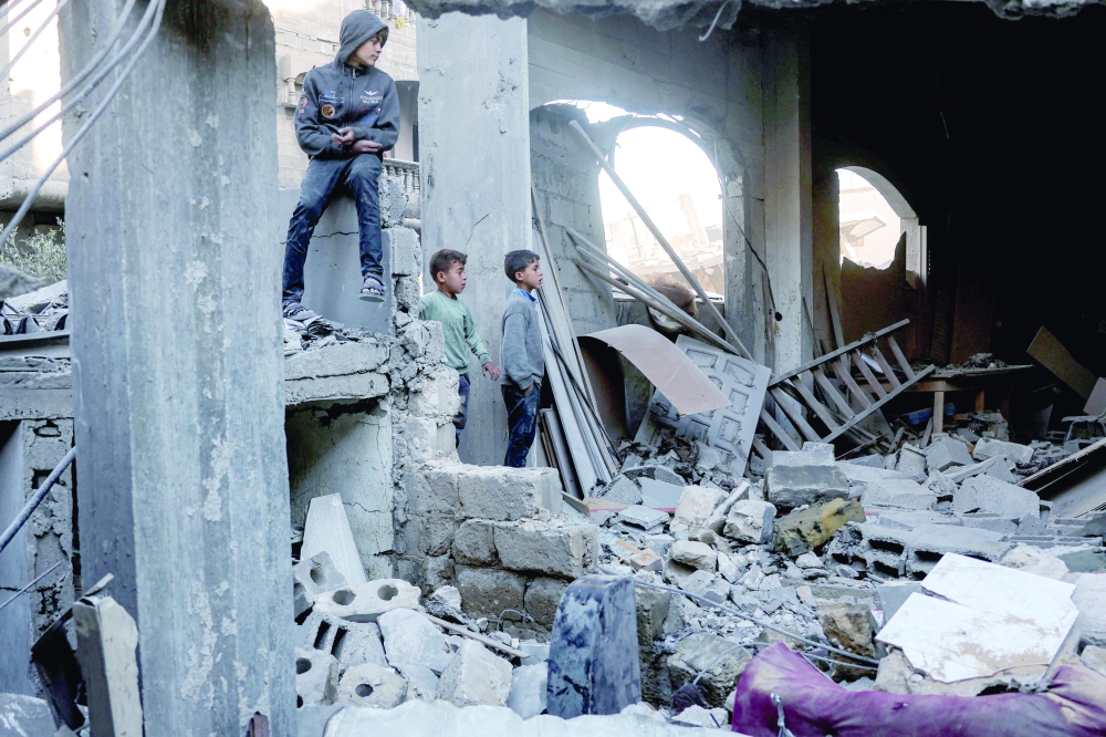 Boys inspect the rubble of a destroyed building that was hit by Israeli bombardment in Jabalia. — AFP