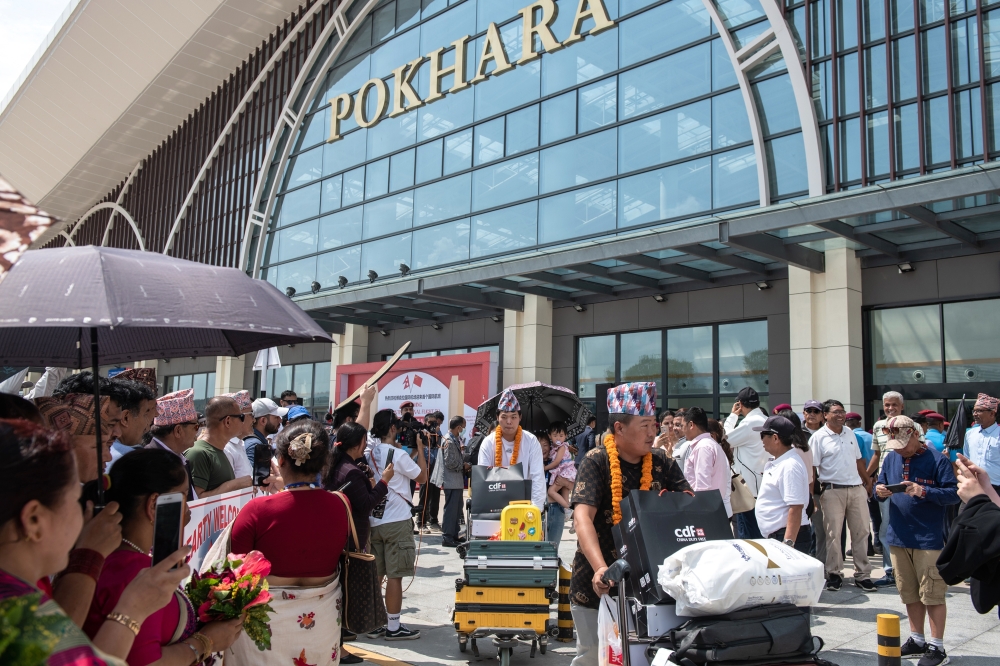 Nepali citizens welcome Chinese passengers from the first international flight to arrive at Pokhara International Airport in Pokhara on June 21, 2023. (Rebecca Conway/The New York Times)