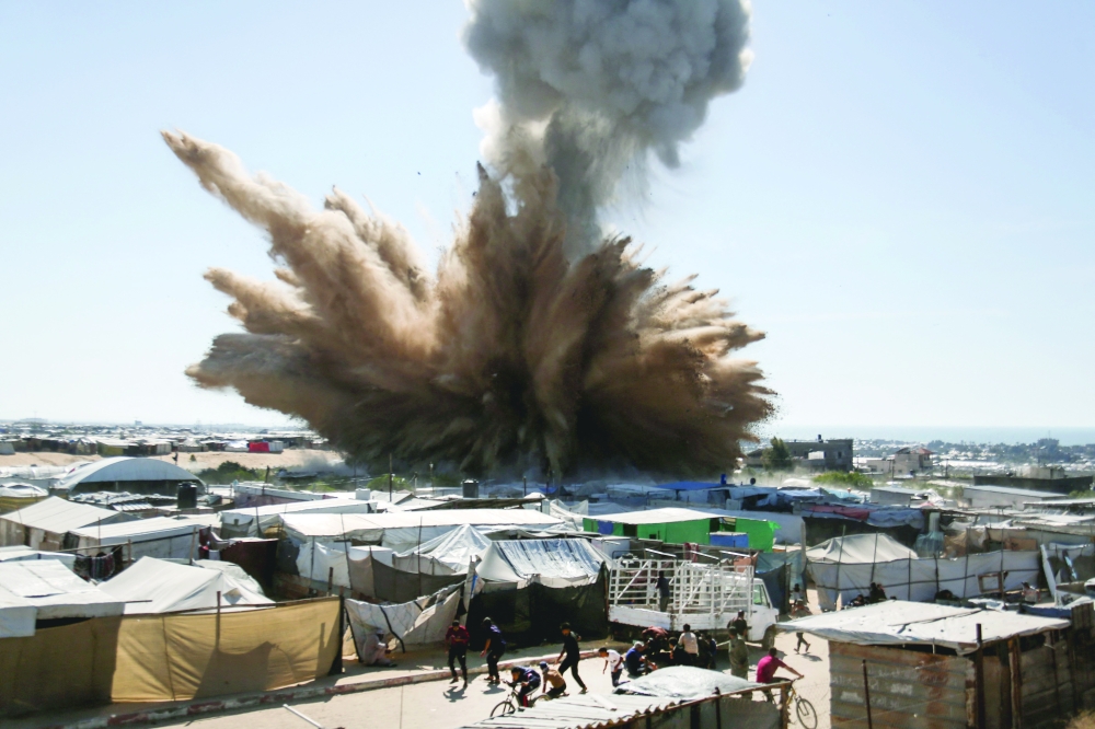 People run for cover as a plume of smoke rises