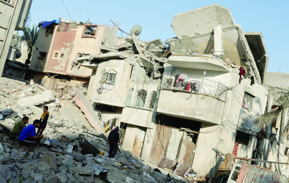 Palestinians gather at the site of an Israeli strike on a house, in Khan Younis in the southern Gaza Strip on Saturday. - Reuters