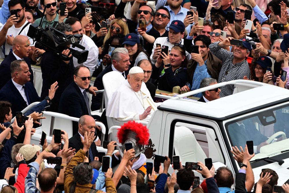 Pope Francis waves to the crowd from the popemobile after the Easter mass, at St Peter's Square in the Vatican. — AFP
