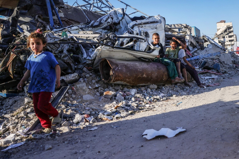 Displaced Palestinian children sit on buildings rubble near a police station-turned-shelter in Gaza City. — AFP