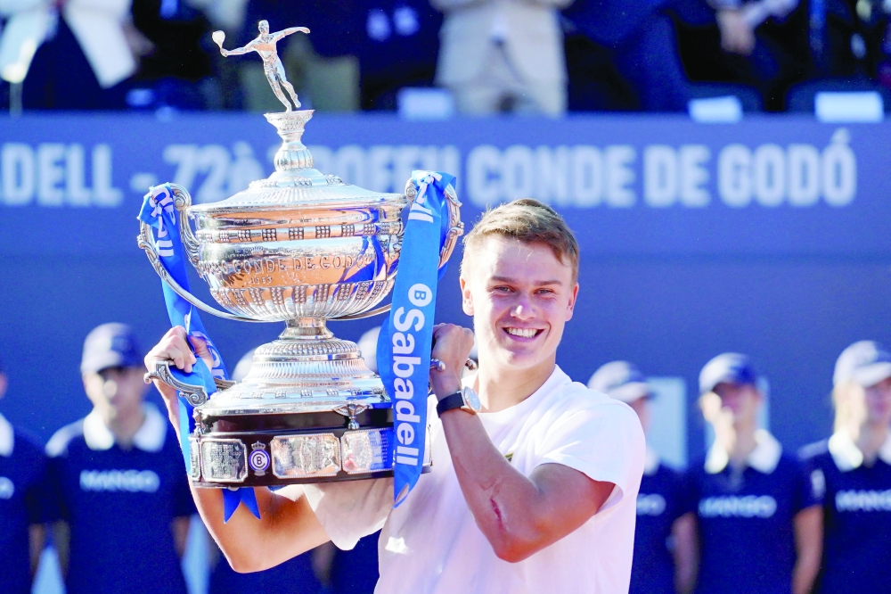 Denmark's Holger Rune holds up the trophy after winning the ATP Barcelona Open. — AFP
