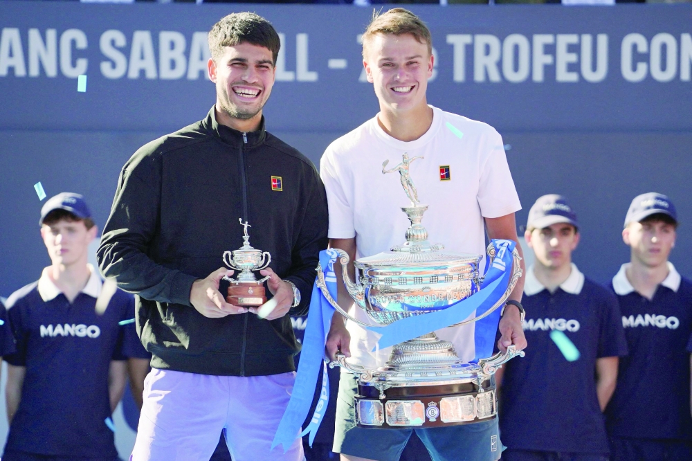 Denmark's Holger Rune (R) and Spain's Carlos Alcaraz hold up their trophies after the ATP Barcelona Open. — AFP