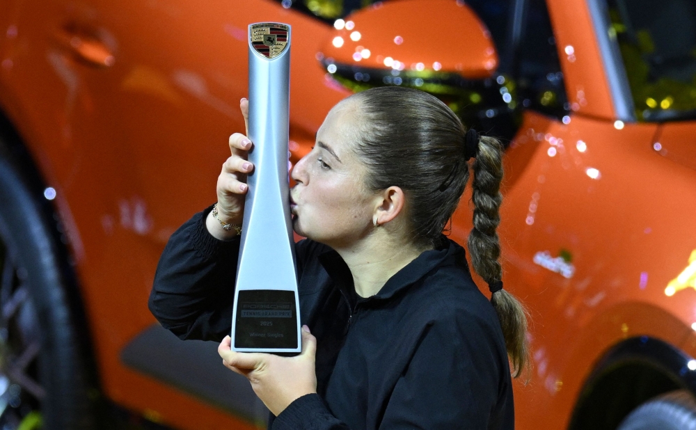 Latvia’s Jelena Ostapenko celebrates with the trophy in front of the winner's car after winning the final match against Belarus’ Aryna Sabalenka. — AFP