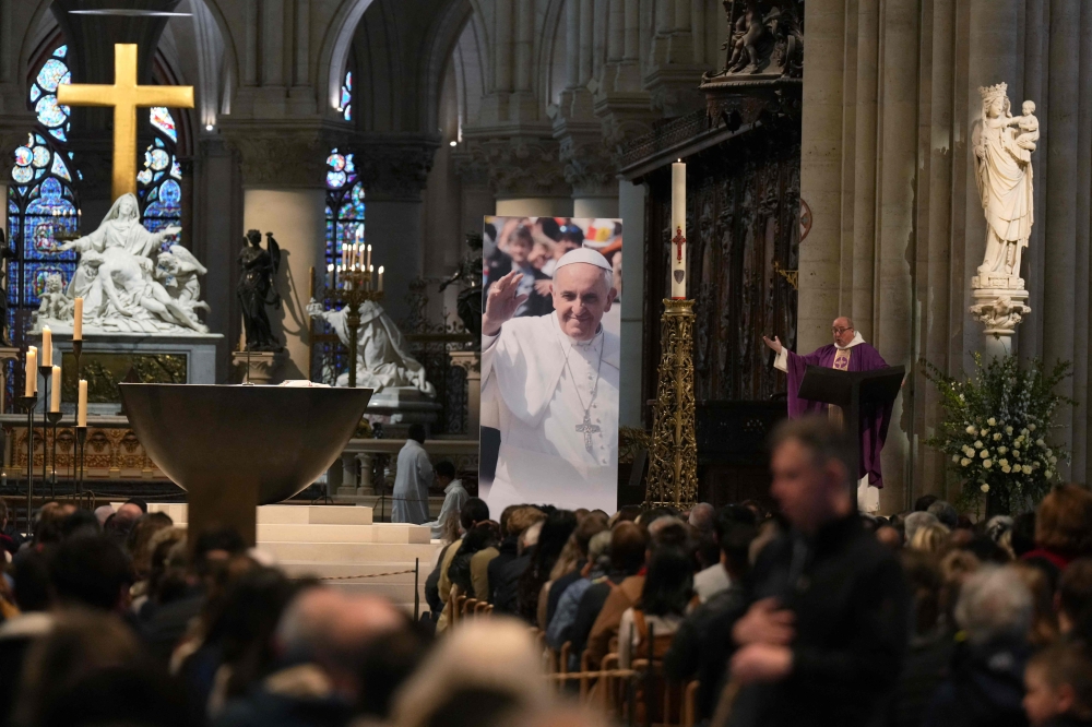 People attend a mass in Notre-Dame Cathedral to honour Pope Francis following his death, in Paris. — AFP