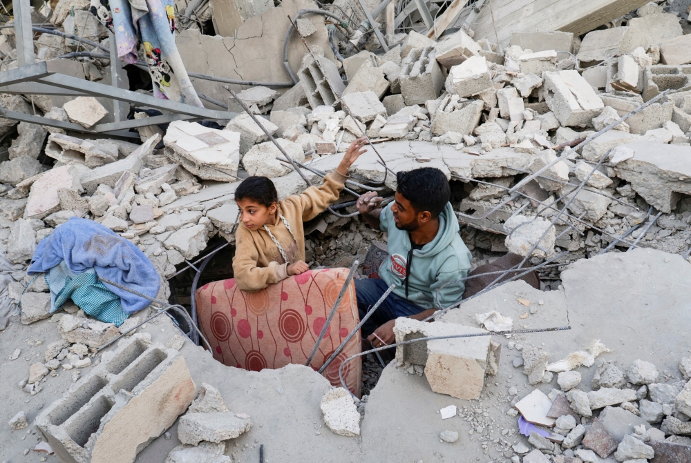 Palestinians inspect the site of an Israeli strike on a house, in Khan Younis in the southern Gaza Strip April 22, 2025.