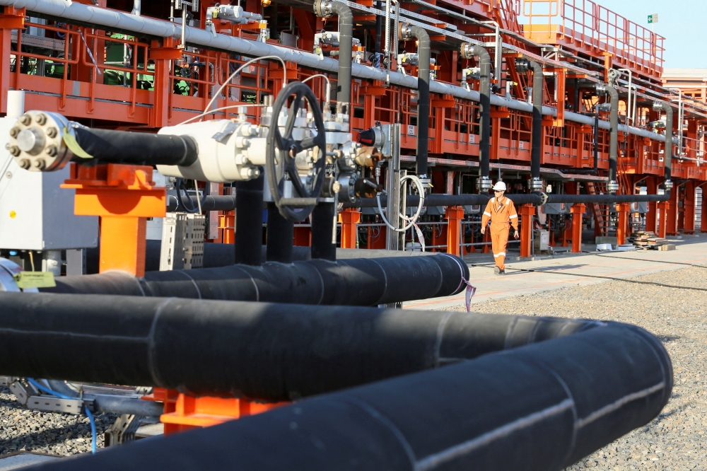 A worker walks past infrastructure on D Island, the main processing hub, at the Kashagan offshore oil field in the Caspian sea in western Kazakhstan