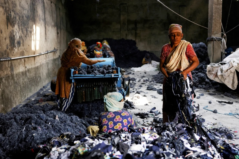 Women work in a factory where fabric waste from garments is transformed into cotton to make mattresses, in Narayanganj, Bangladesh. - Reuters