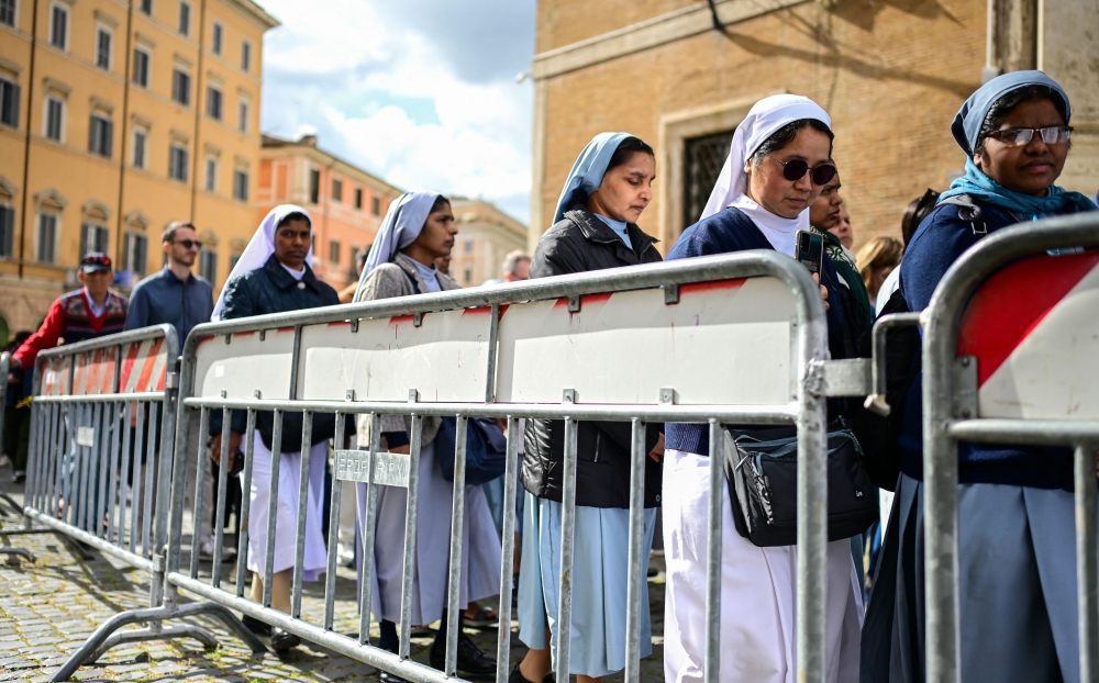 Nuns and visitors queue next to a barrier to enter Santa Maria Maggiore Basilica. — AFP