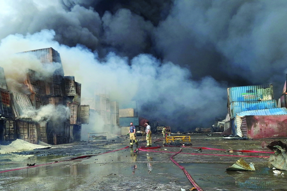 Firefighters and rescuers work at the Shahid Rajaee port dock, southwest of Bandar Abbas. — AFP