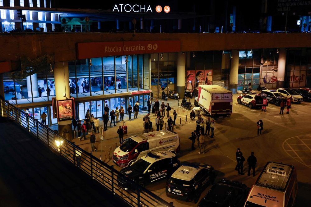 Ambulances and police cars are parked outside Atocha station in Madrid