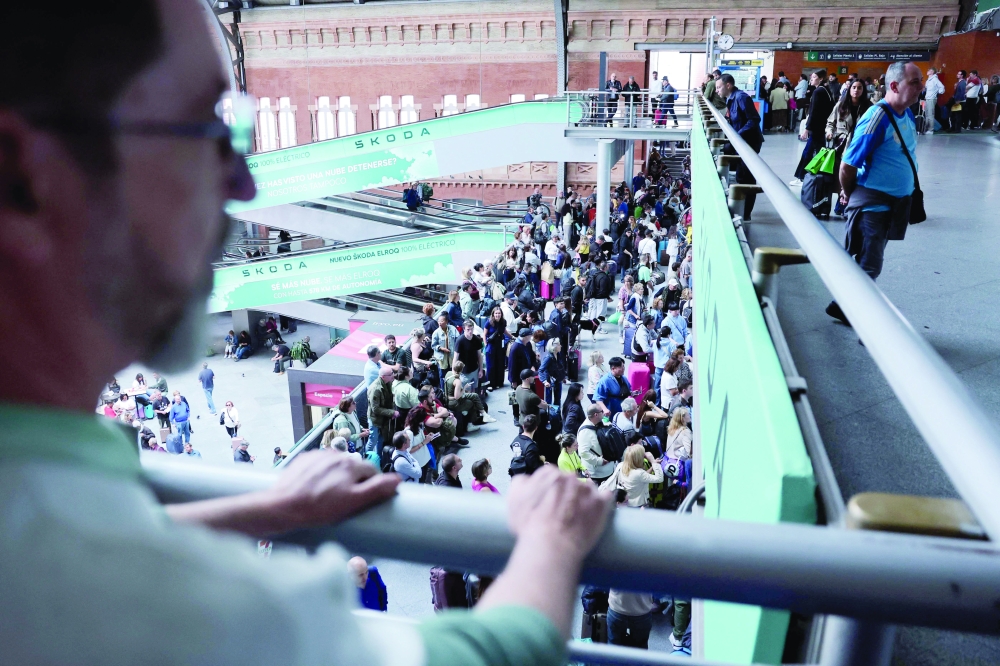 Passengers wait for their trains at Atocha station in Madrid the day after a power cut affecting the entire peninsula and the south of France. — AFP