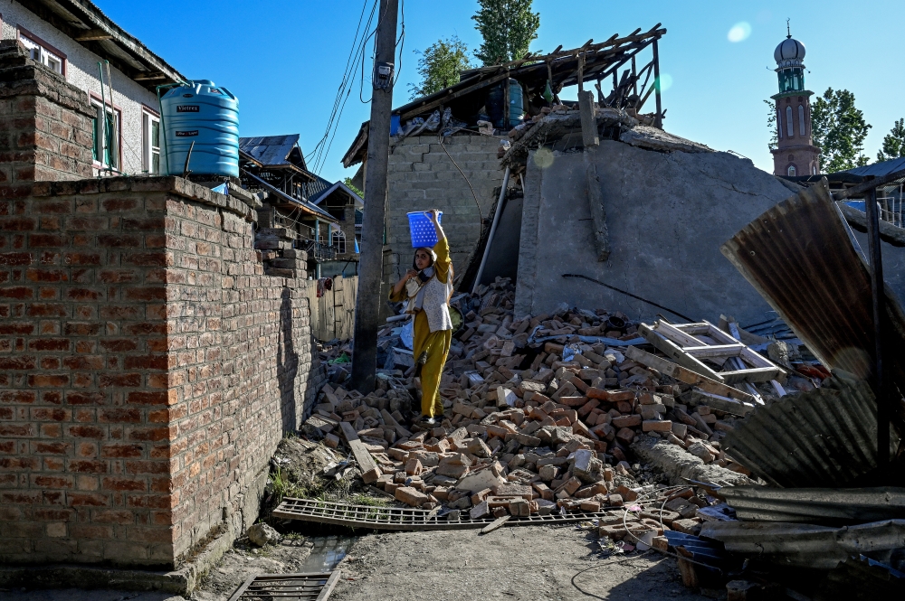 A local navigates the debris of a house demolished by Indian authorities over its owner's purported connections to the recent terrorist attack, in Murran village, Pulwama district, Kashmir on April 29, 2025.