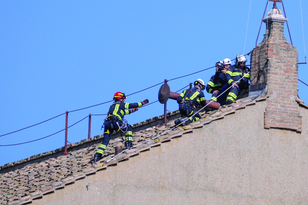 Firefighters work on the roof of the Sistine Chapel to set a chimney, at the Vatican. — Reuters