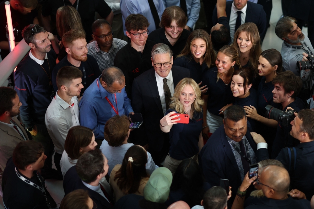  Britain's Prime Minister Keir Starmer (C) poses for a selfie photo with members of staff