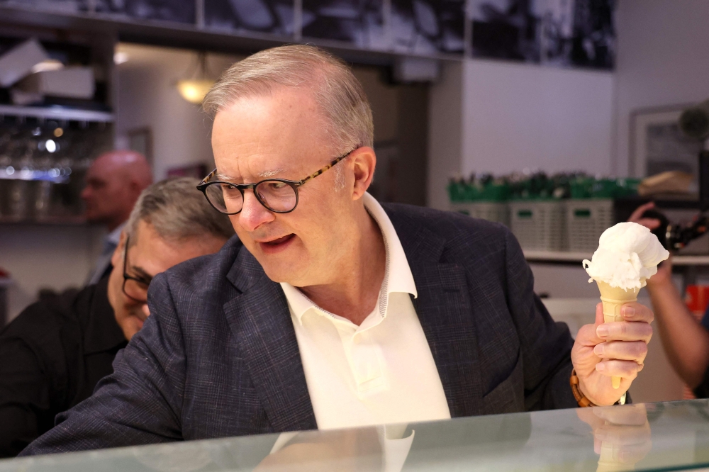Australia's re-elected Prime Minister Anthony Albanese hands an ice cream order to a customer during a visit to a cafe in Sydney on May 4, 2025, following his party痴 decisive federal election victory.  (Photo by DAVID GRAY / AFP)
