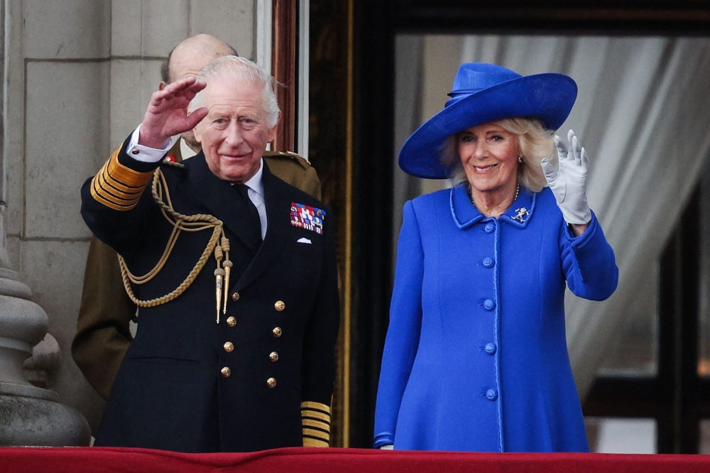 Britain's King Charles III and Britain's Queen Camilla wave to crowds, on the balcony of Buckingham Palace after attending the armed forces procession on Monday. - AFP